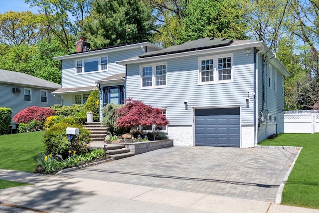 19 Morewood Oaks Prt, Washington, NY 11050 - split level home featuring roof mounted solar panels, an attached garage, a front lawn, and decorative driveway