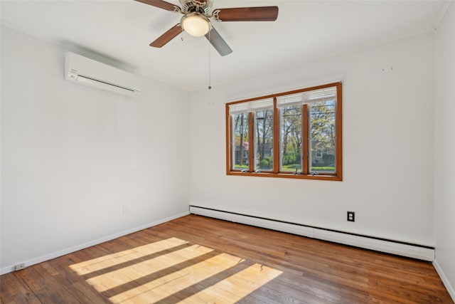 spare room featuring baseboards, a baseboard radiator, a wall unit AC, and hardwood / wood-style floors