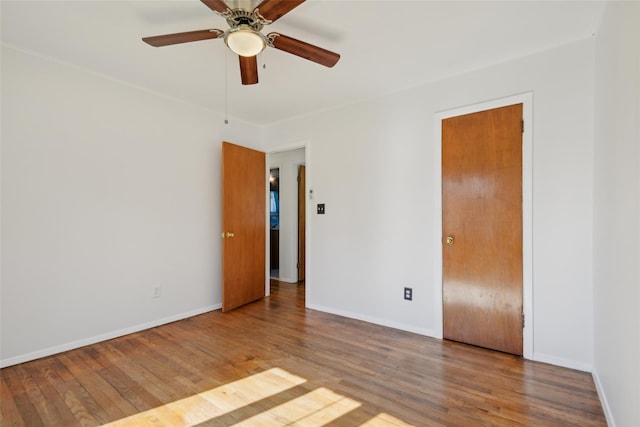 unfurnished bedroom with a ceiling fan, baseboards, and wood finished floors