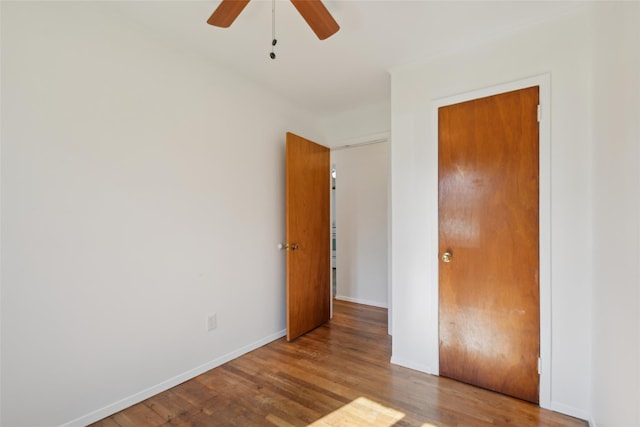 unfurnished bedroom with baseboards, a ceiling fan, and wood finished floors