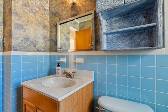 half bath with toilet, tile walls, and vanity
