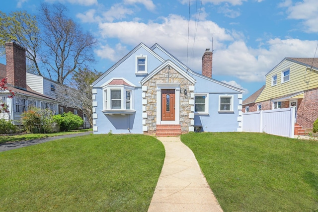 bungalow-style home with a chimney, fence, a front lawn, entry steps, and stucco siding