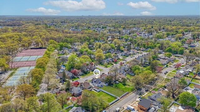 drone / aerial view featuring a residential view and a view of trees
