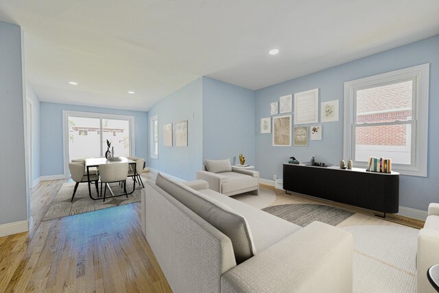 living area featuring baseboards, plenty of natural light, and wood finished floors