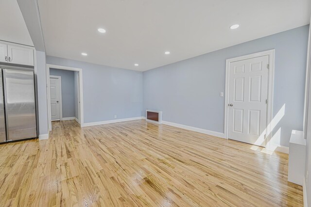 unfurnished living room featuring recessed lighting, baseboards, and light wood finished floors