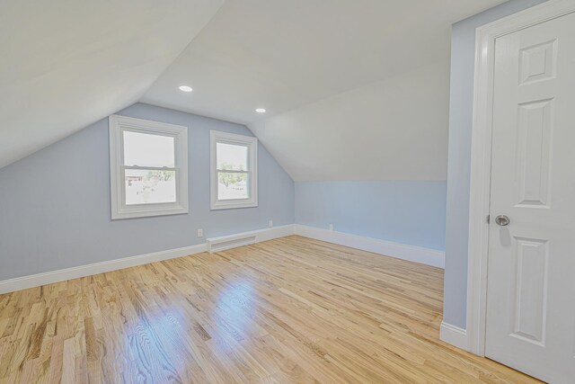 additional living space featuring visible vents, vaulted ceiling, wood finished floors, baseboards, and recessed lighting