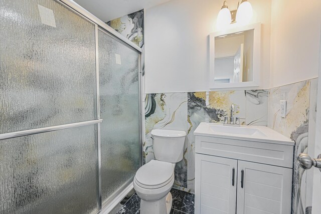 full bath with tile walls, a stall shower, vanity, toilet, and marble finish floor