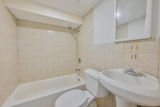 full bathroom with toilet, tile walls, shower / tub combination, and a sink