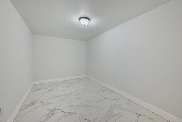 empty room with baseboards and marble finish floor