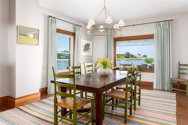 0 Rich, Greenwich, CT 06830 - dining room featuring baseboards, a water view, wood finished floors, and a notable chandelier