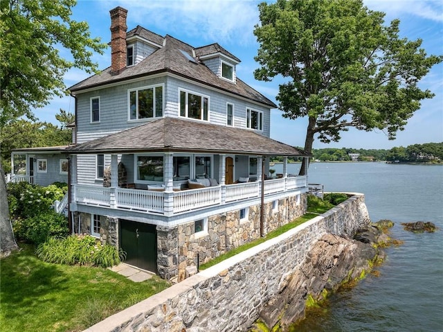 0 Rich, Greenwich, CT 06830 - view of front of home with a water view, a chimney, stone siding, and a balcony