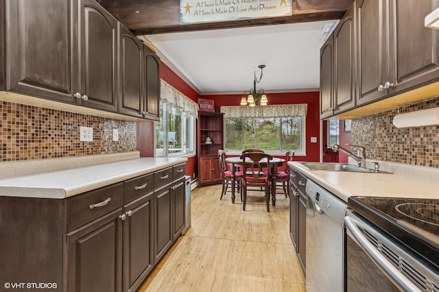 kitchen featuring dark brown cabinets, appliances with stainless steel finishes, a sink, light countertops, and light wood-style flooring
