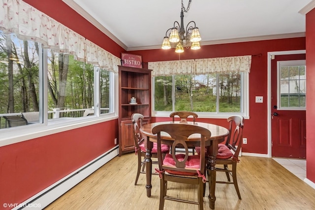 dining space with baseboards, light wood-style flooring, a baseboard heating unit, and a notable chandelier