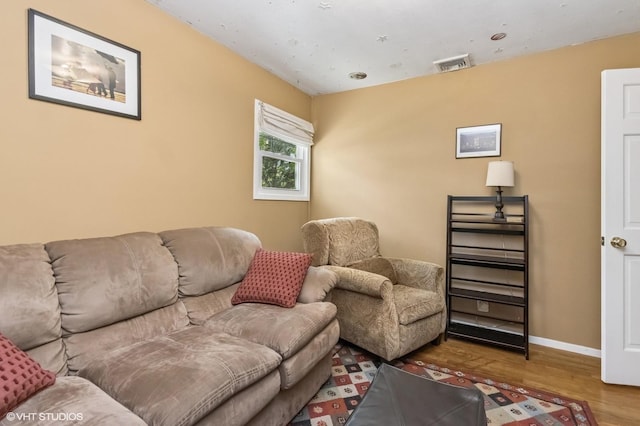 living room featuring baseboards, wood finished floors, and visible vents