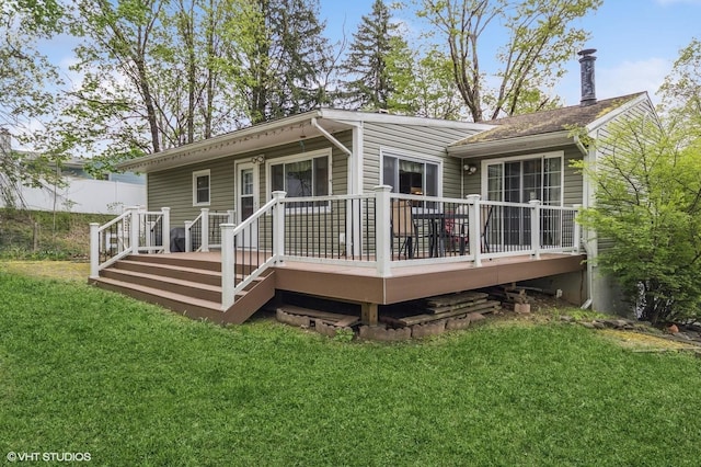 back of property with a lawn and a wooden deck