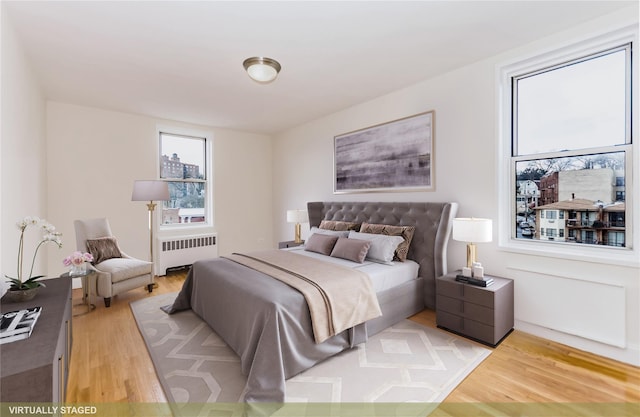bedroom featuring radiator and light wood-type flooring