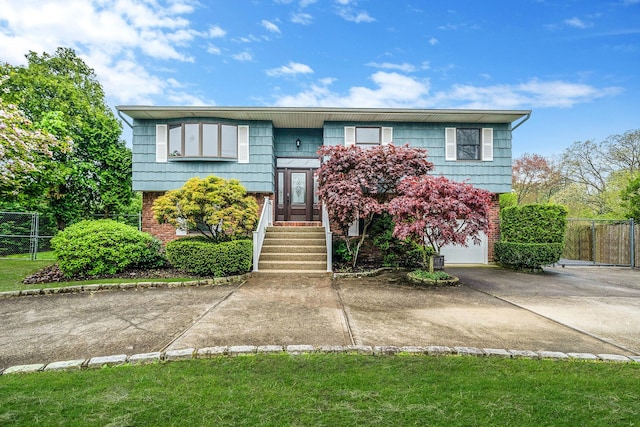 40 Cedarhurst St, Islip Terrace, NY 11752 - split foyer home with concrete driveway, brick siding, fence, and a garage
