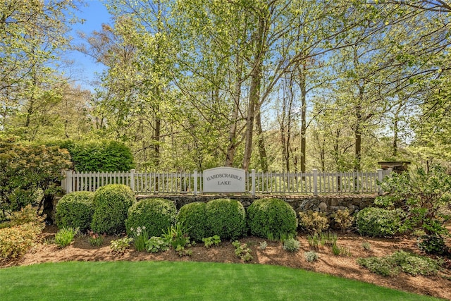 community sign with a lawn and fence