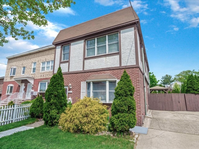 view of front of home with brick siding and fence