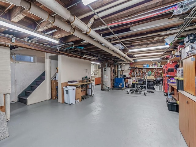 unfinished below grade area featuring water heater and stairway