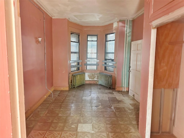 230 Sunnyside Ave, Brooklyn, NY 11207 - unfurnished room with radiator heating unit, baseboards, and crown molding