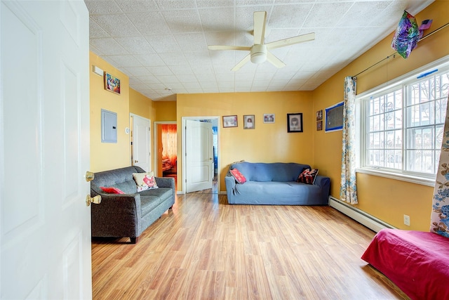 living room featuring ceiling fan, baseboard heating, and wood finished floors