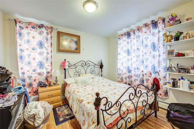 bedroom featuring a baseboard radiator and wood finished floors