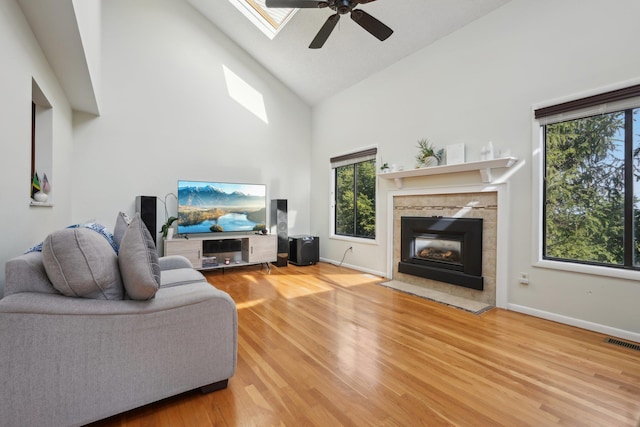 living room with high vaulted ceiling, visible vents, plenty of natural light, and ceiling fan