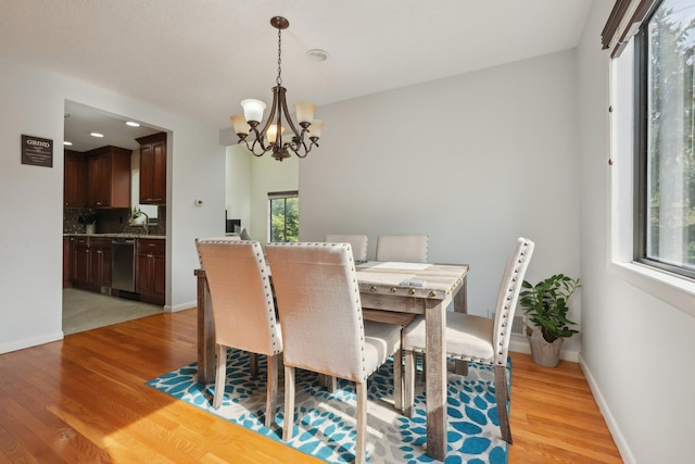 dining room with an inviting chandelier, recessed lighting, light wood-style flooring, and baseboards