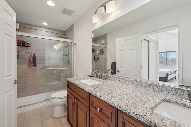 ensuite bathroom with visible vents, a sink, and a shower stall