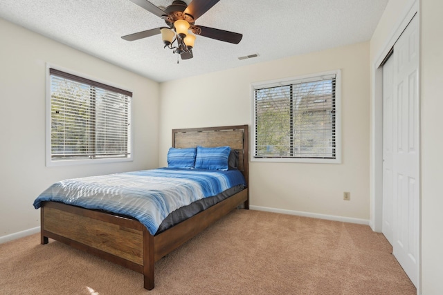 bedroom with carpet flooring, baseboards, visible vents, and multiple windows