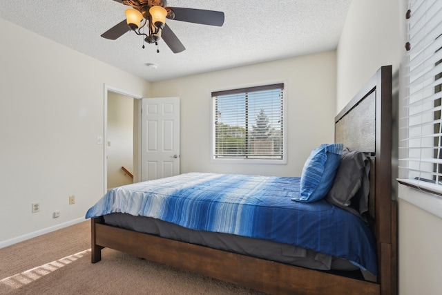 bedroom with carpet floors, baseboards, a ceiling fan, and a textured ceiling