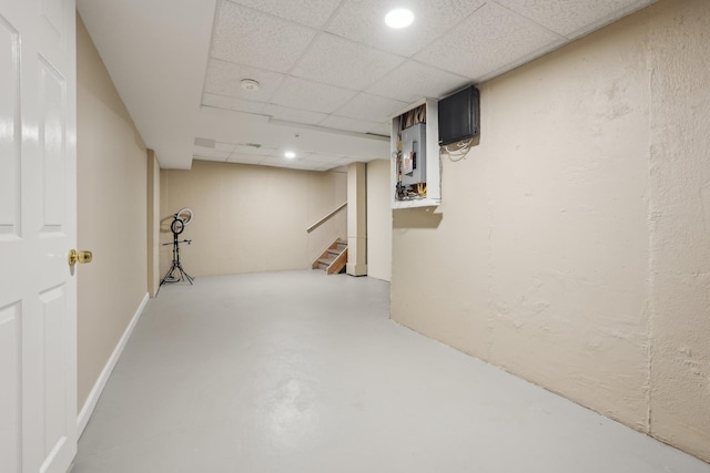 finished below grade area featuring recessed lighting, a drop ceiling, and stairs