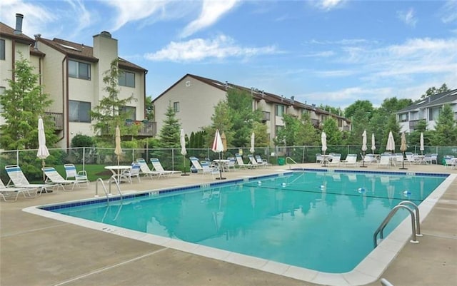 pool featuring fence, a residential view, and a patio area
