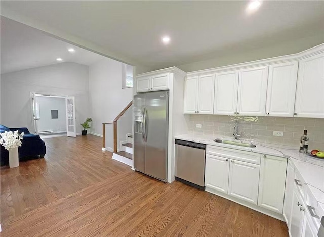 47 Ontario St, Port Jefferson Station, NY 11776 - kitchen featuring white cabinetry, tasteful backsplash, a sink, appliances with stainless steel finishes, and vaulted ceiling