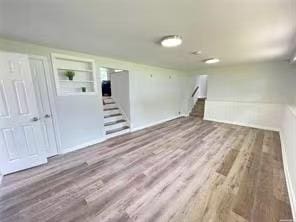 47 Ontario St, Port Jefferson Station, NY 11776 - below grade area featuring built in shelves, wood finished floors, and stairway