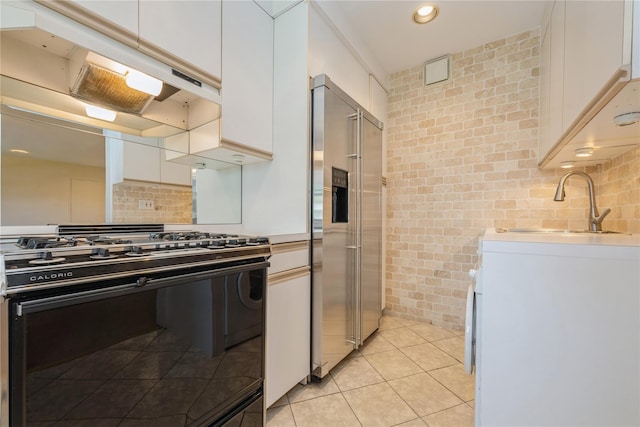 19-32 202nd St Apt # 1-179, Whitestone, NY 11360 - kitchen with a sink, white cabinetry, under cabinet range hood, high quality fridge, and black gas range