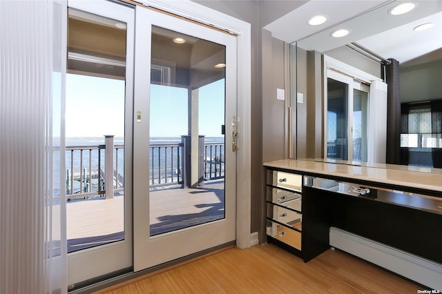 bathroom featuring recessed lighting, a water view, and wood finished floors