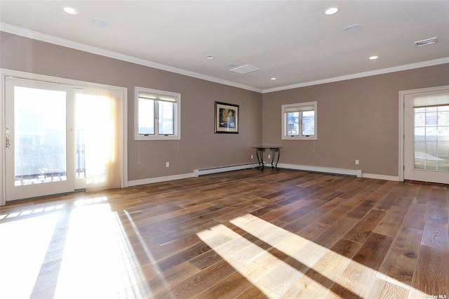 empty room featuring crown molding, baseboards, a baseboard heating unit, and wood finished floors