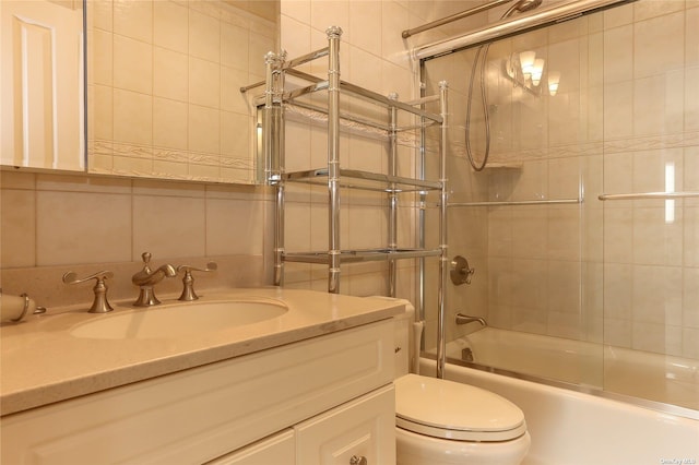 bathroom with vanity, enclosed tub / shower combo, backsplash, and toilet