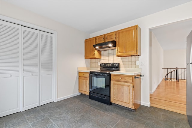 405 Driftway Ln, Brewster, NY 10509 - kitchen with black range with electric cooktop, under cabinet range hood, light countertops, decorative backsplash, and baseboards