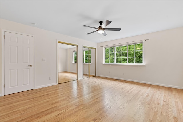 405 Driftway Ln, Brewster, NY 10509 - unfurnished bedroom featuring multiple closets, light wood-style floors, baseboards, and ceiling fan