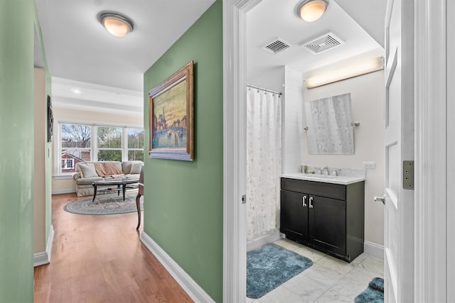 full bath with baseboards, vanity, wood finished floors, and visible vents
