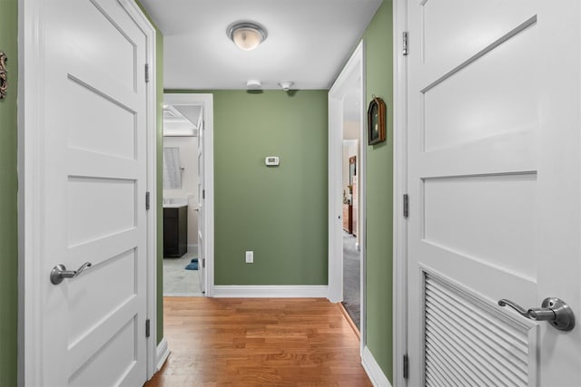 hall featuring baseboards and wood finished floors