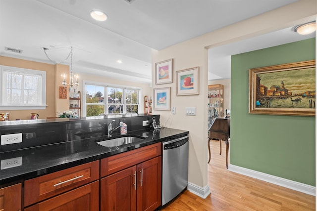 kitchen with a wealth of natural light, a sink, light wood finished floors, and dishwasher
