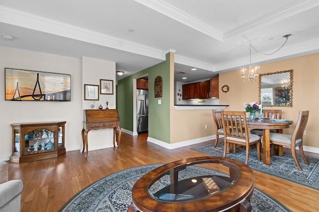 dining area featuring crown molding, baseboards, wood finished floors, and a chandelier