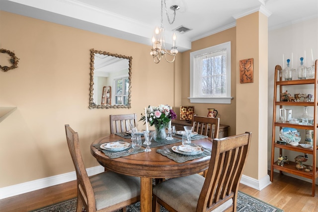 dining area featuring ornamental molding, visible vents, a healthy amount of sunlight, and wood finished floors