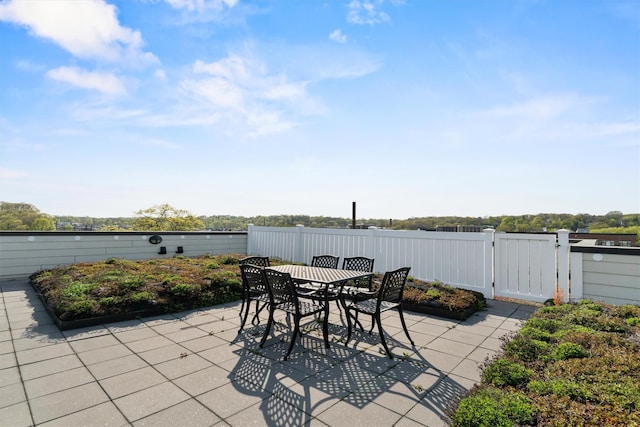 view of patio / terrace featuring fence, outdoor dining area, and a gate