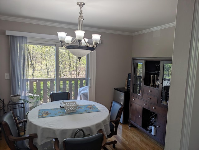dining room featuring crown molding, light wood finished floors, and a chandelier