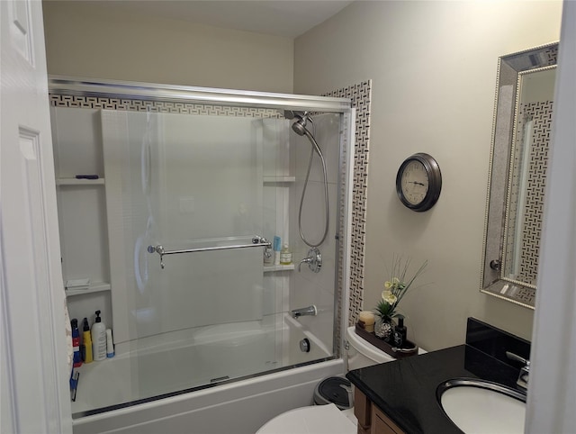 full bathroom with vanity, bath / shower combo with glass door, and toilet